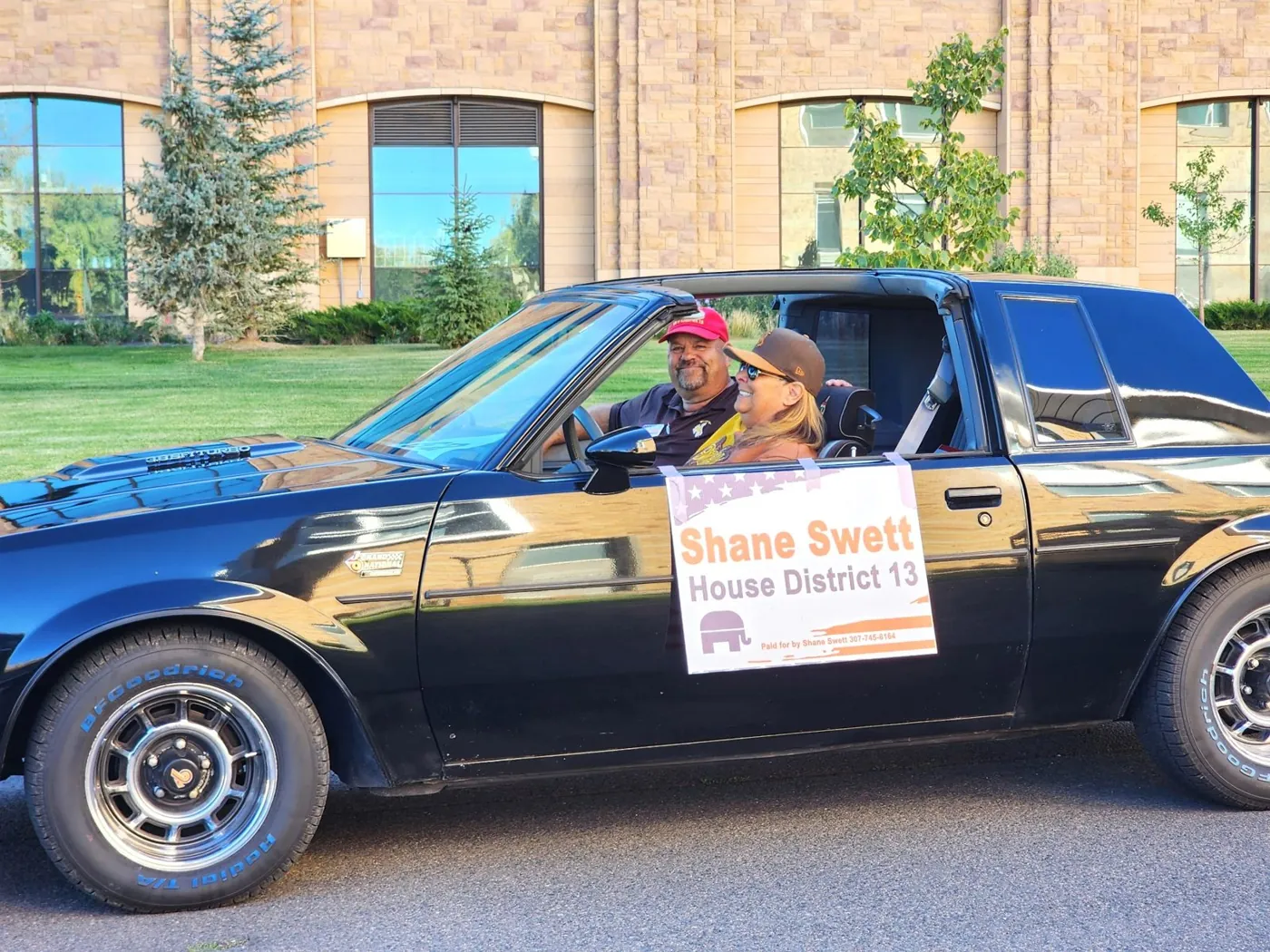 Shane Swett driving a classic black car with a Shane Swett House District 13 campaign sign in Laramie